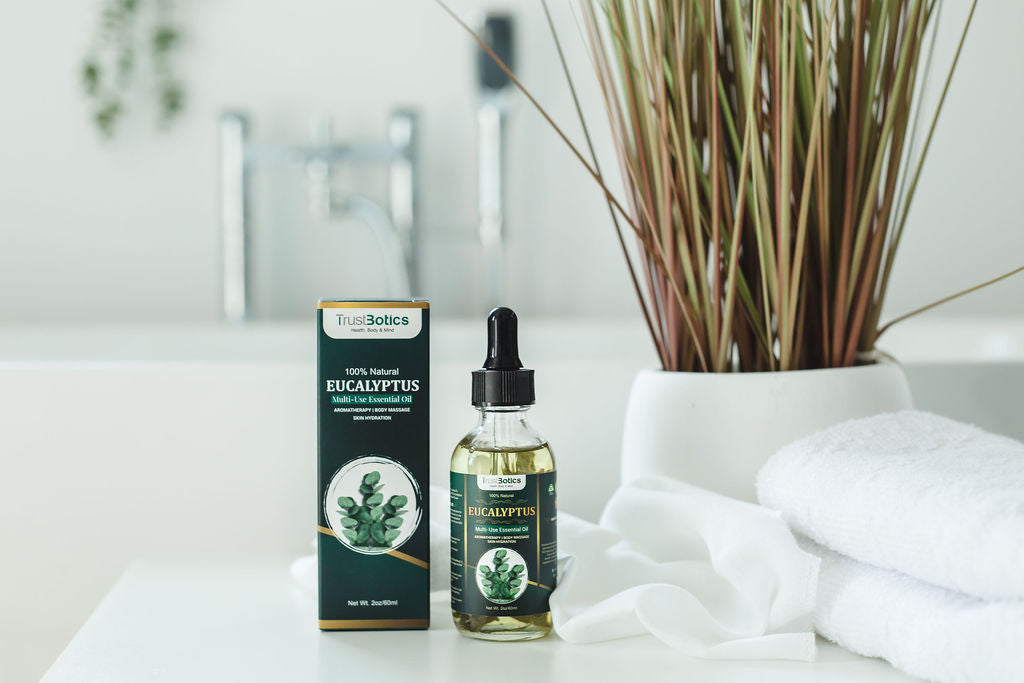 TrustBotics Eucalyptus Essential Oil bottle with box on a clean, spa-inspired bathroom counter featuring towels and decorative reeds, highlighting natural freshness and purity.