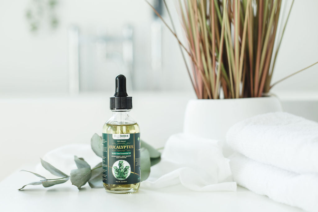 TrustBotics Eucalyptus Essential Oil bottle styled with eucalyptus leaves, towels, and spa decor for a fresh, luxurious skincare and aromatherapy vibe.
