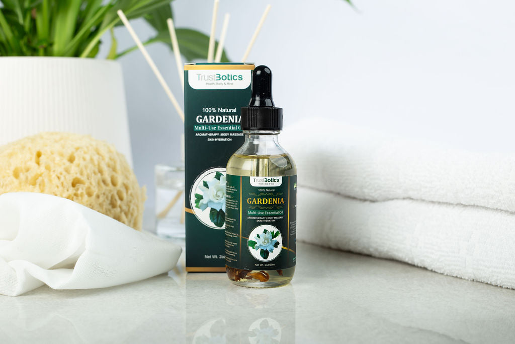 TrustBotics Gardenia Essential Oil bottle with packaging – displayed on a spa-like setting with sponge, towel, and diffuser sticks, emphasizing luxury floral skincare and relaxation.