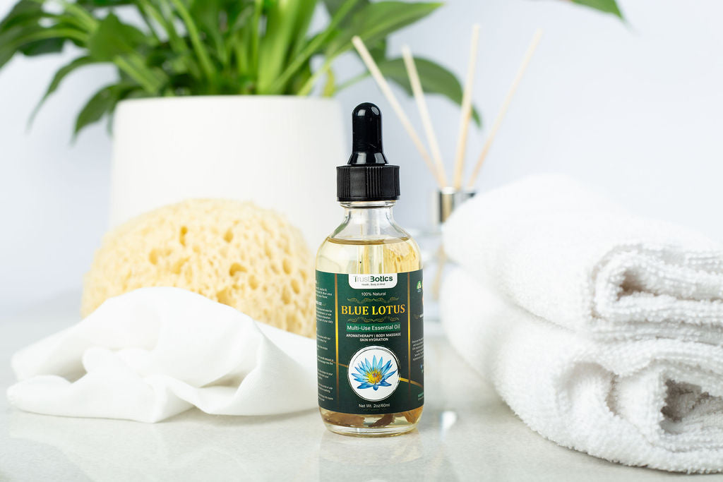 TrustBotics Blue Lotus Essential Oil bottle in spa setting with towels, diffuser, sponge, and greenery, creating a serene and luxurious atmosphere.