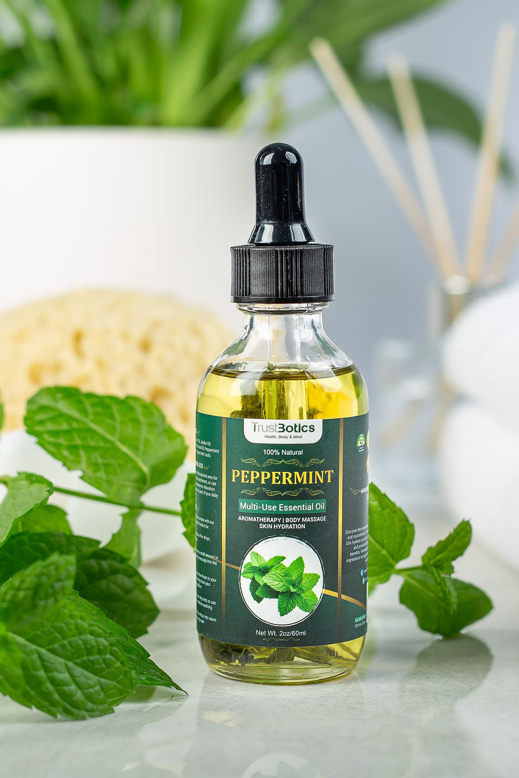 Premium TrustBotics Peppermint Essential Oil bottle surrounded by fresh mint leaves, showcasing luxury aromatherapy and skincare.