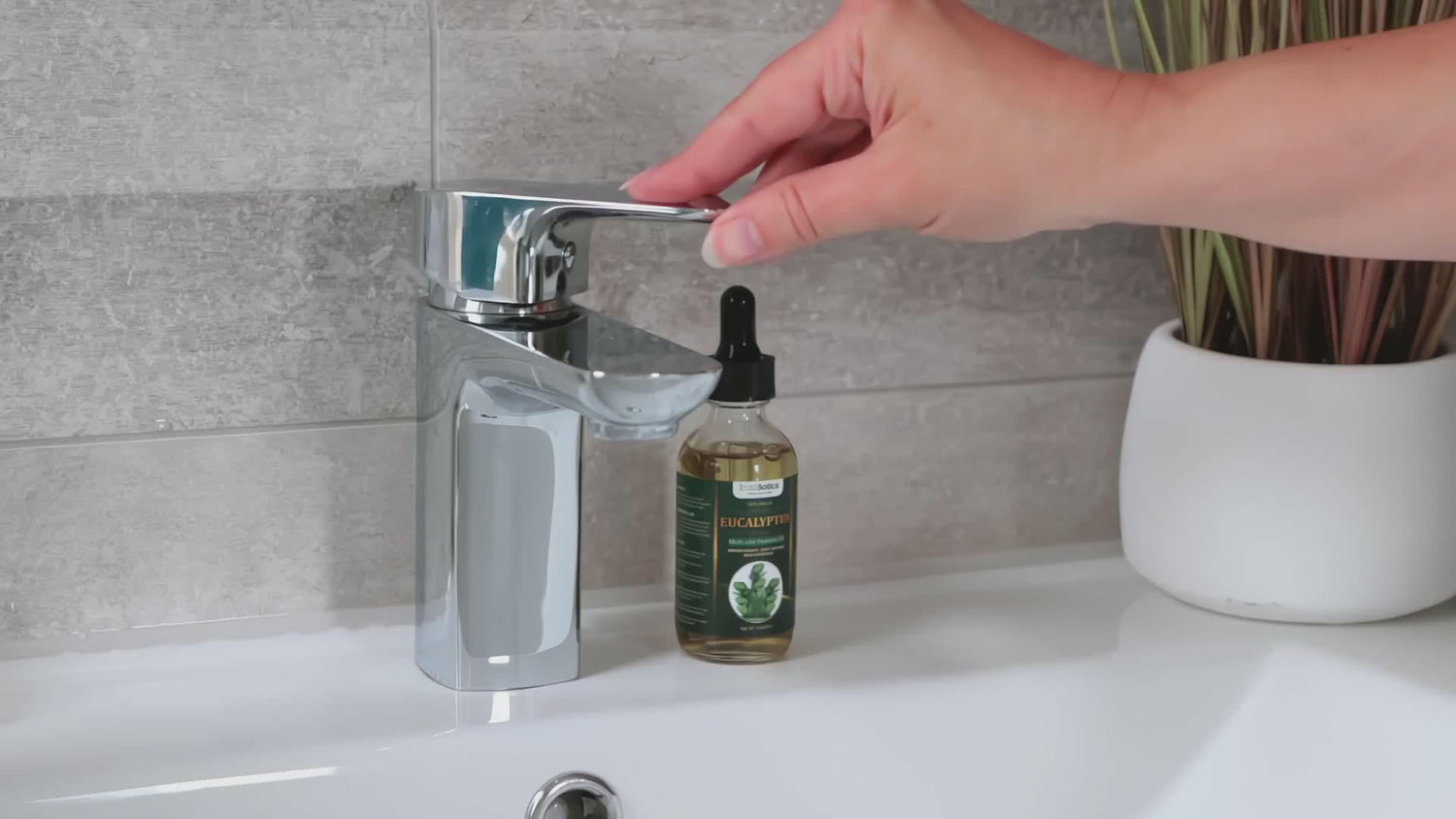 TrustBotics Eucalyptus Oil placed by a flowing tap – a simple ritual to bring clarity, refreshment, and natural care into your daily routine.