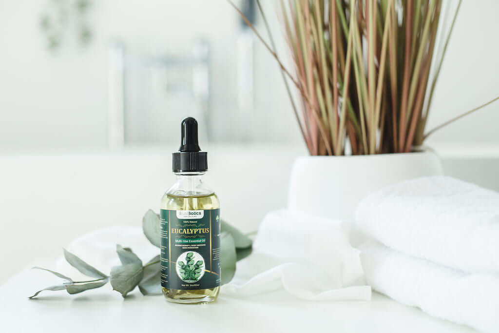 TrustBotics Eucalyptus Multi-Use Essential Oil bottle styled with eucalyptus leaves, towels, and spa decor for a fresh, luxurious skincare and aromatherapy vibe.