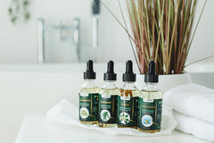 TrustBotics multi-use essential oils including neroli, rosemary, blue lotus and green bonnie displayed in a calm spa inspired bathroom setting for aromatherapy and daily wellness rituals