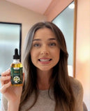 Woman holding TrustBotics Neroli multi-use essential oil bottle, natural aromatherapy oil for daily wellness rituals, skin care and calming self-care routine